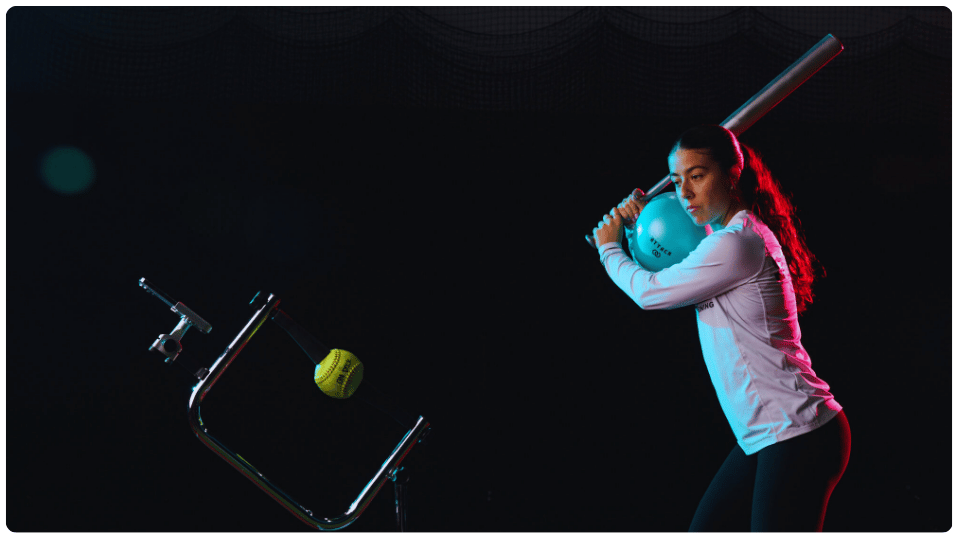 Proper Tee Placement for Softball: The Complete 9 - Zone Guide 5 Female athlete practicing proper tee placement for softball with bat ready to swing at a stationary ball on training tee