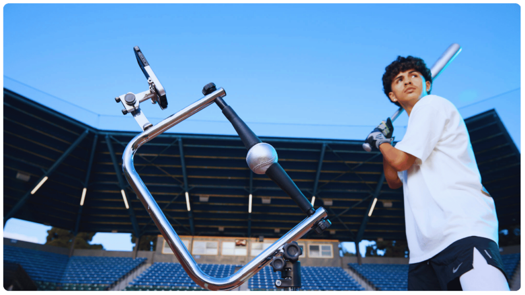 Teen baseball player preparing to swing at the Attack Tee in a stadium setting, highlighting the best batting tee for kids baseball practice.